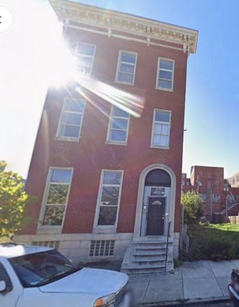 A red brick building with a black door and windows.