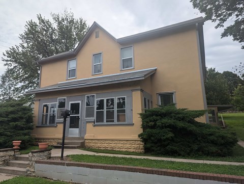 A house with a grey roof and a yellow exterior.