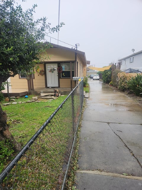 A house with a white door and a fence on the side.