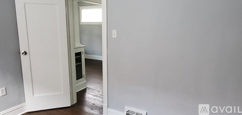 A white door is open to a hallway.