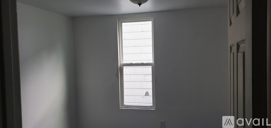 A window with blinds in a room with white walls.