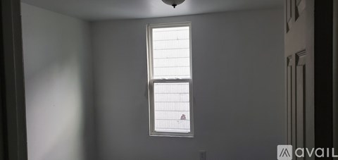 A window with blinds in a room with white walls.
