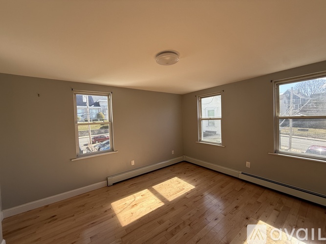 A room with wooden floors and two windows.