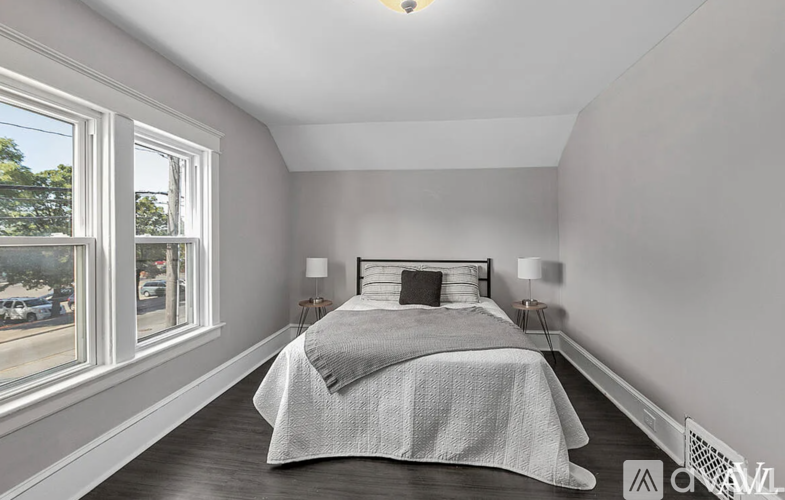 A bedroom with a large bed and a window overlooking a street.