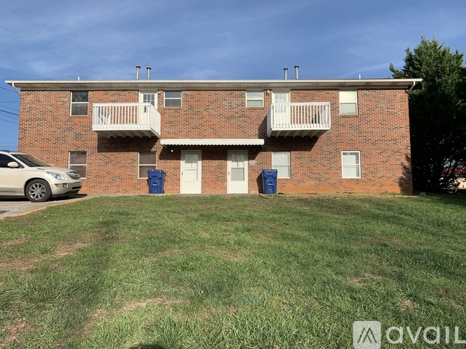 A brick apartment building with a car parked in front.