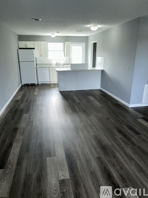 A room with wooden flooring and white walls.