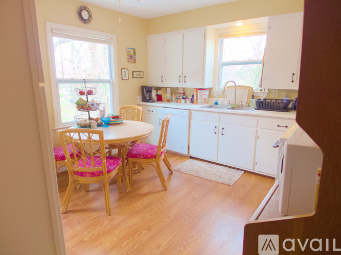 A kitchen with a table and chairs in front of a window.