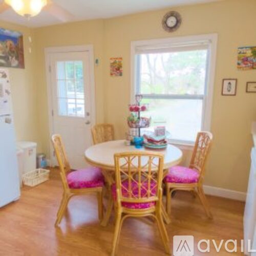 A dining room with a white table and chairs.