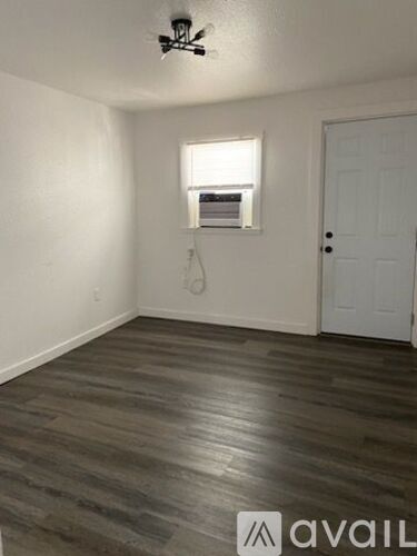 A room with a white door and a window with blinds.