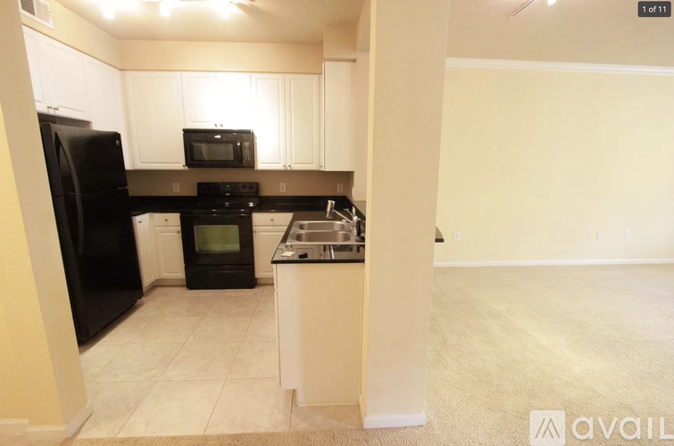 A kitchen with black appliances and white cabinets.