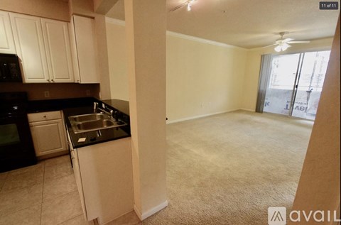 A kitchen with white cabinets and black appliances.