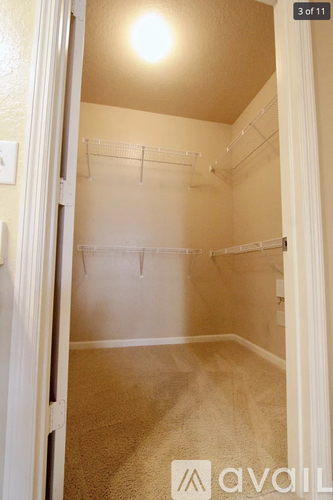 A small, empty room with a carpeted floor and a doorway leading to another room.