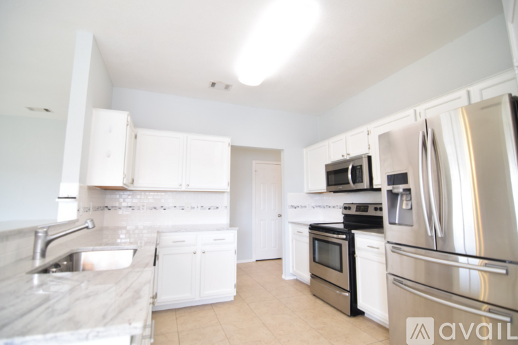 A kitchen with white cabinets and stainless steel appliances.