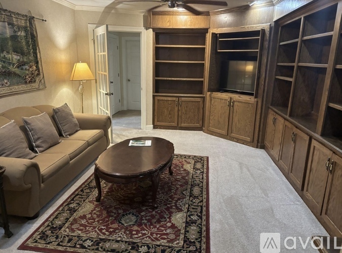 A living room with a couch, a coffee table, and a rug.
