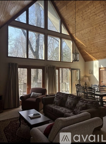 A living room with a couch, chairs, and a coffee table.