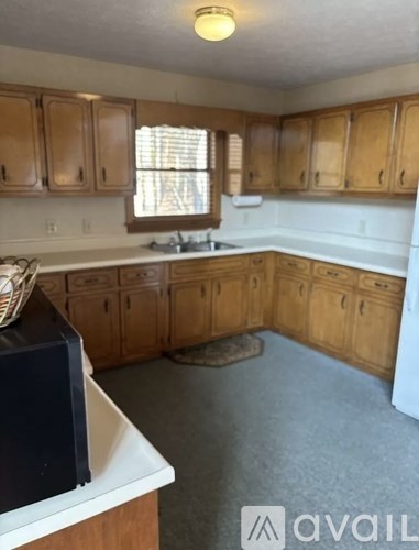 A kitchen with wooden cabinets and a white dishwasher.