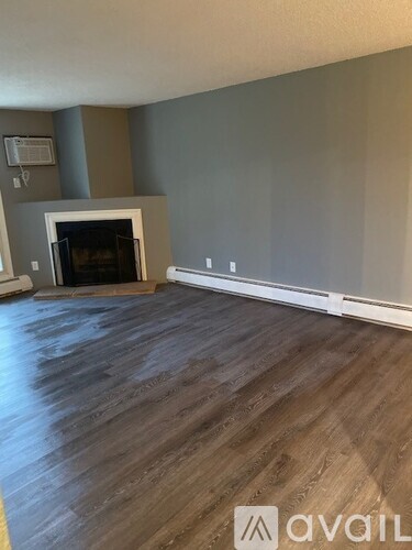 A room with a fireplace and wooden flooring.
