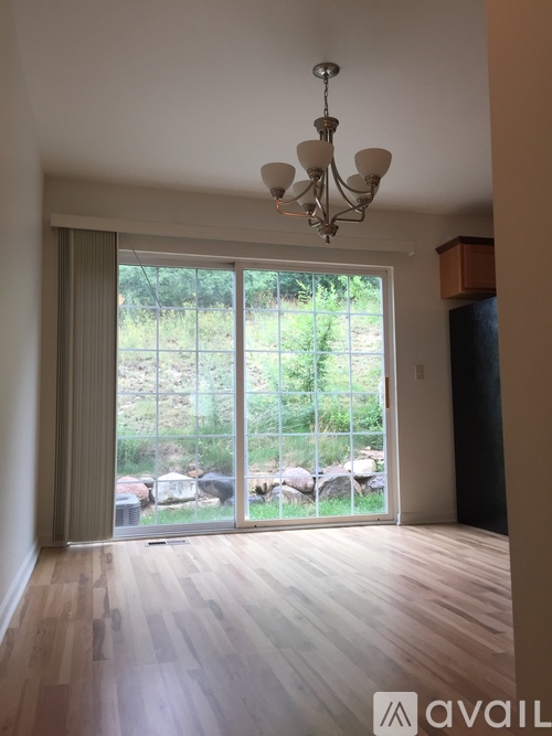 A room with a chandelier and sliding glass doors leading to a garden.