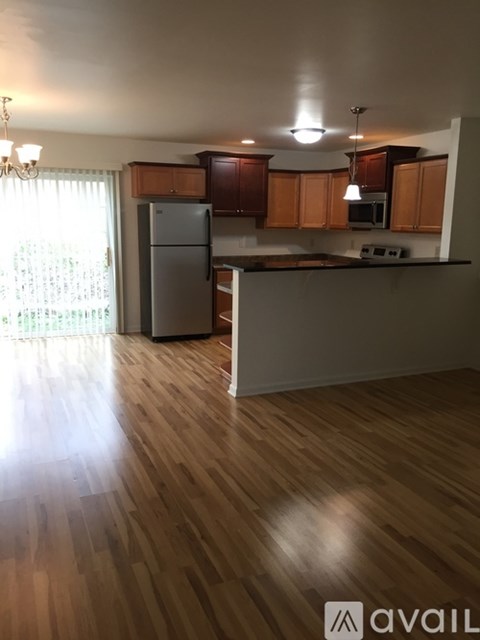 A kitchen with wooden floors and a refrigerator.