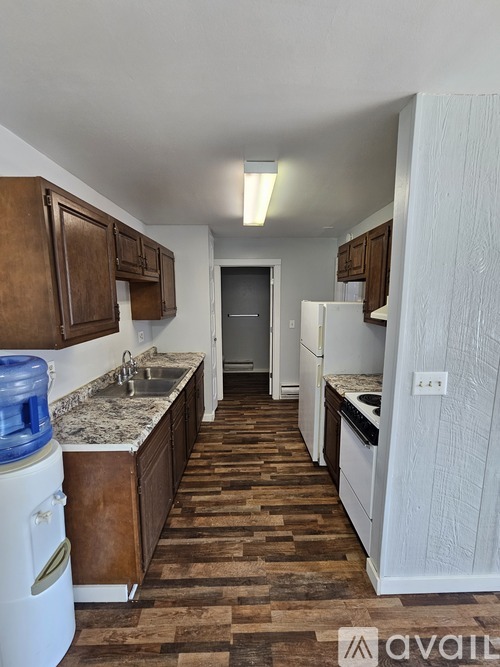 A kitchen with brown cabinets and a white fridge.