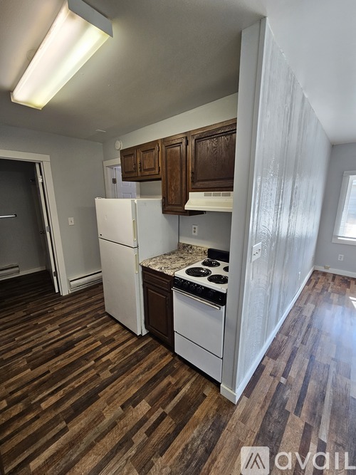 A kitchen with wooden floors and white appliances.