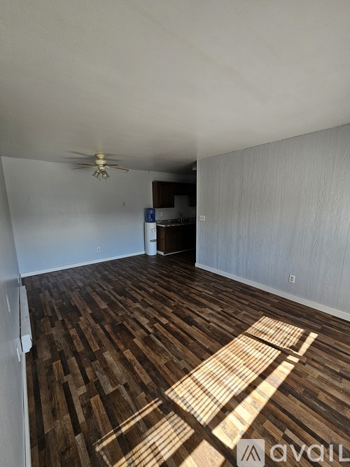 A room with wooden flooring and a ceiling fan.