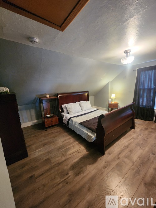 A bedroom with a bed, nightstand, and lamp.
