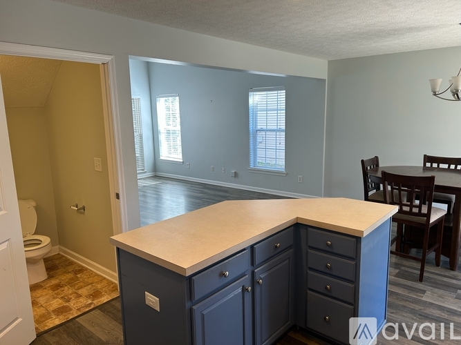 A kitchen with a countertop, cabinets, and a dining table.