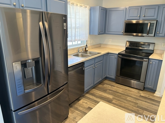 A modern kitchen with a stainless steel refrigerator and oven.