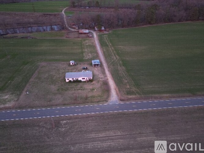 A farm with a white barn and a red tractor.
