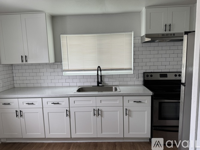 A kitchen with white cabinets and a black stove top oven.