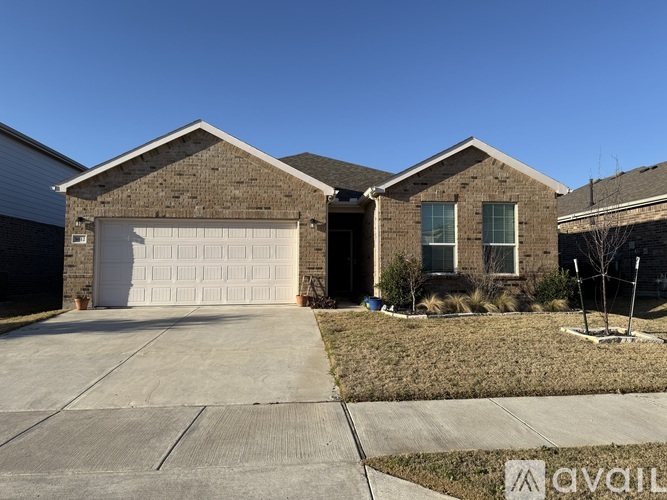 A house with a white garage door and a brown brick exterior.