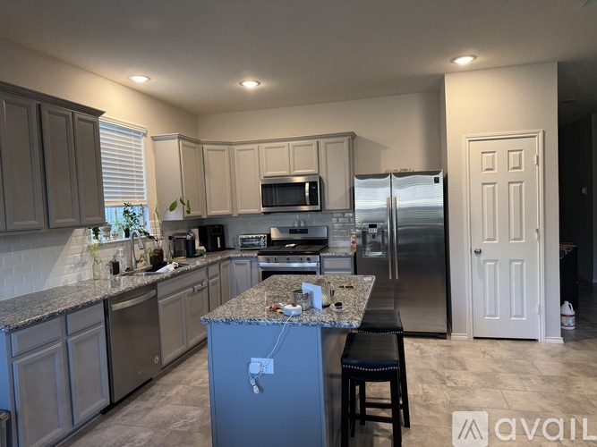 A kitchen with a granite countertop and stainless steel appliances.
