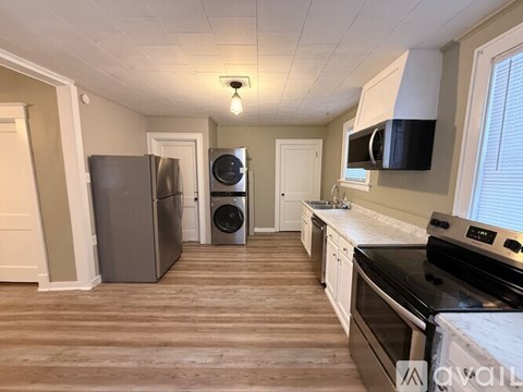 A kitchen with a black stove top oven and a black microwave above it.