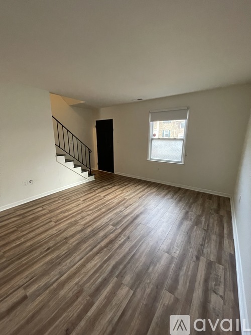 A room with wooden flooring and a staircase.