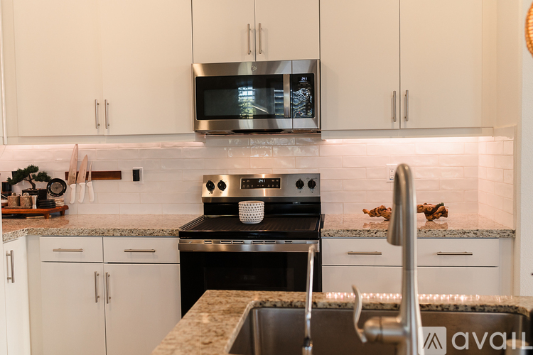 A modern kitchen with a stove top oven and microwave above it.