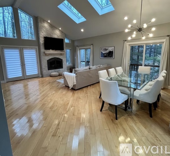 A spacious living room with a fireplace and a glass table.