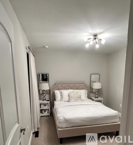 A bedroom with a bed, nightstands, and a ceiling fan.