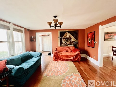 A living room with a blue couch and orange chair.