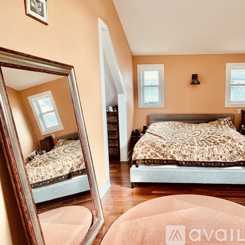 A bedroom with two beds and a large mirror.