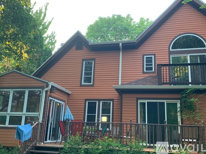 A house with a brown exterior and a balcony with a railing.