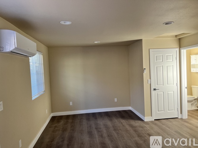 A room with a white door and a window with blinds.