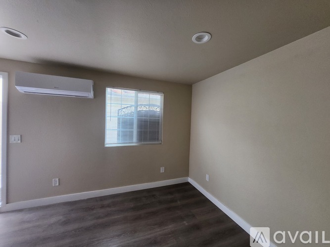 A room with a window and a wall-mounted air conditioner.