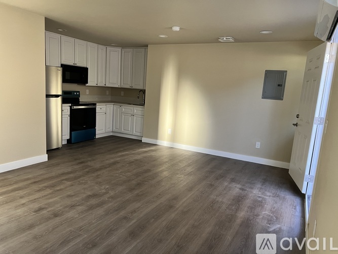 A kitchen with white cabinets and a wooden floor.
