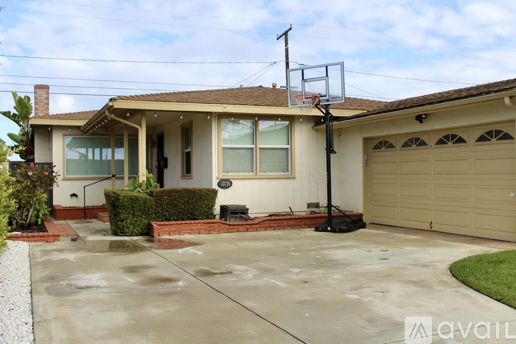 A house with a basketball hoop in the driveway.