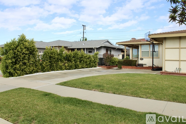 A house with a driveway and a tree in front of it.