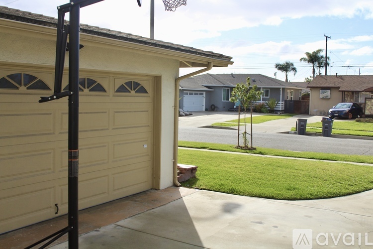 A black basketball hoop stands in front of a garage.