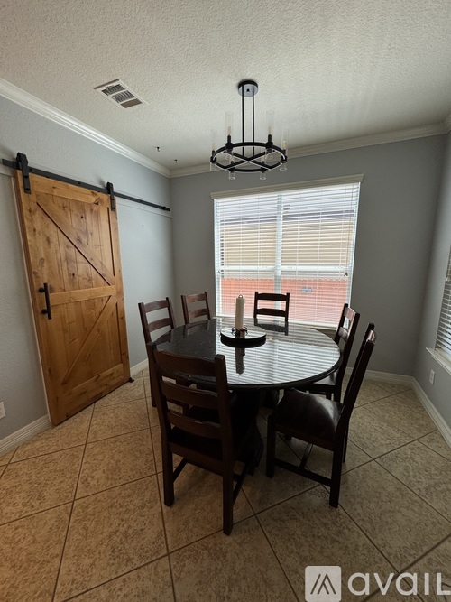 A dining room with a round table and chairs.