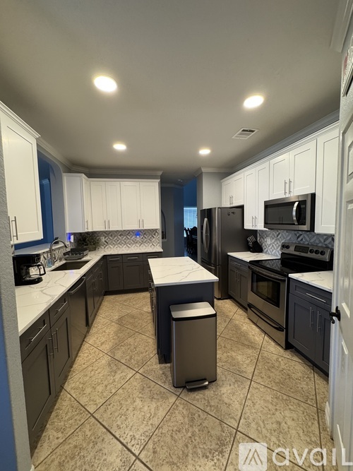 A kitchen with black appliances and white cabinets.