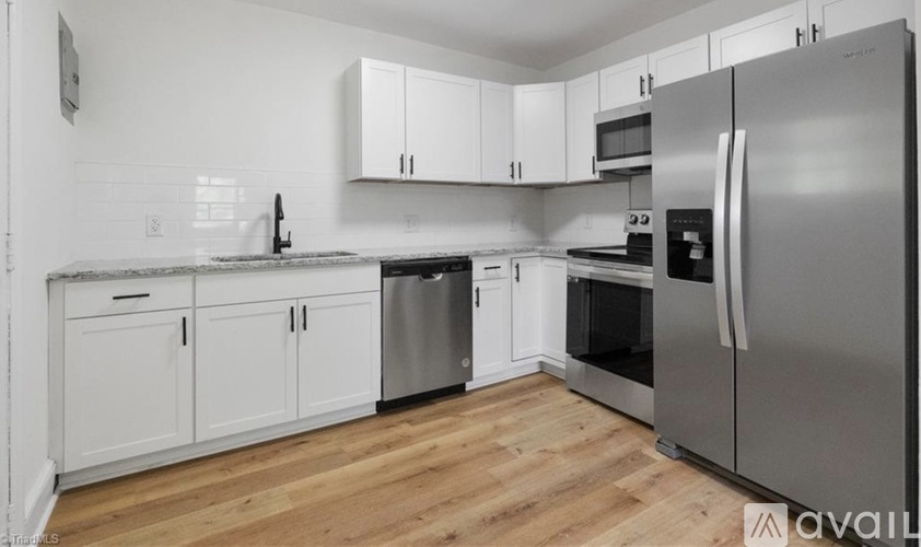 A kitchen with white cabinets and stainless steel appliances.